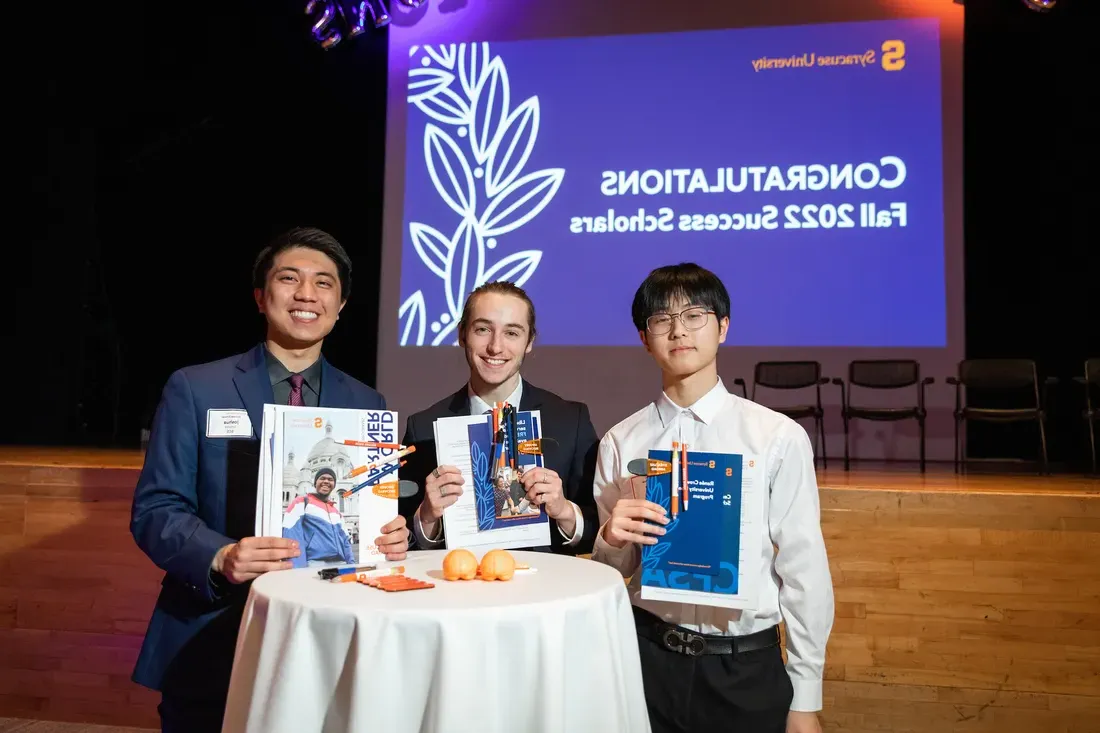 Three students posing for a photo after receiving a scholarship.